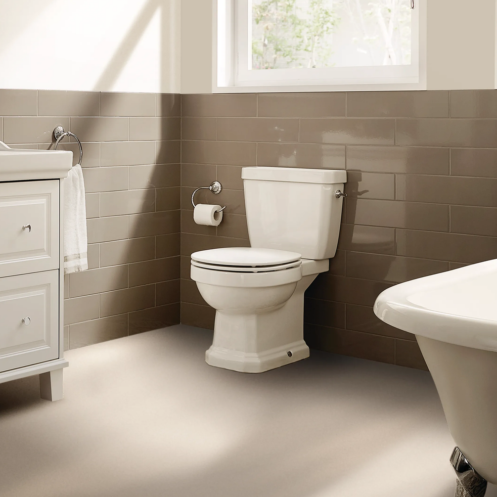Lifestyle image of the Roca Carmen Rimless Close Coupled Toilet within a traditional styled bathroom with brown tiles